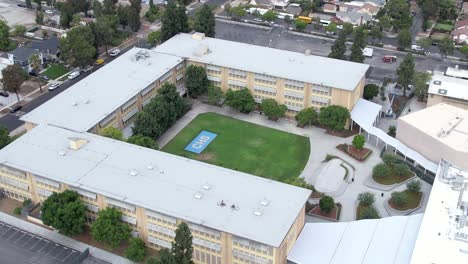 Crenshaw-public-secondary-high-school-aerial-view-pull-away-above-rooftop-Los-Angeles-California