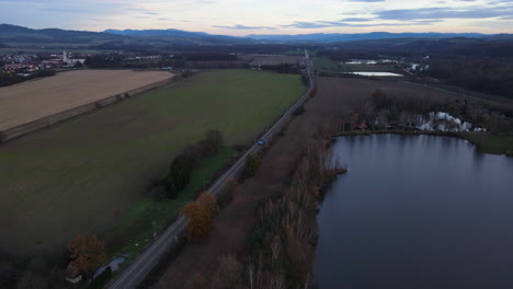 Aerial-view-of-train-tracks-in-the-middle-of-nature-surrounded-by-fields-and-trains