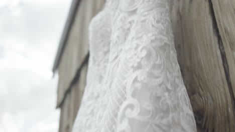 Bride's-white-wedding-dress-hanging-on-the-door