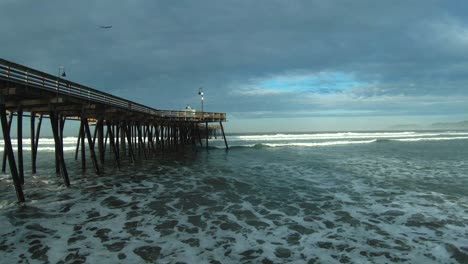 Low-altitude-flight-alongside-the-Pismo-Beach-pier-and-under-the-wooden-support-at-dawn