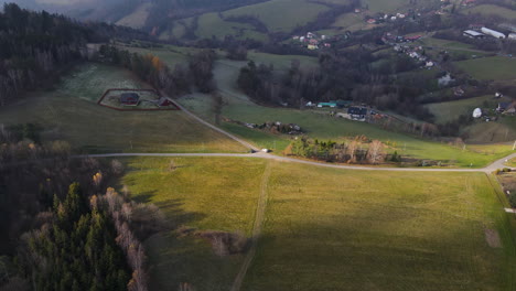 Aerial-view-of-a-landscape-surrounded-by-barracks-in-the-middle-of-a-hilly-landscape-with-sun-rays
