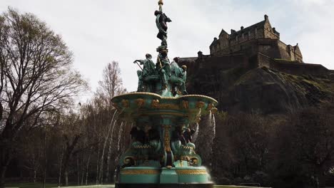 Fountain-in-Princes-Street-Gardens-with-water-flowing-and-Edinburgh-famous-castle-in-the-background