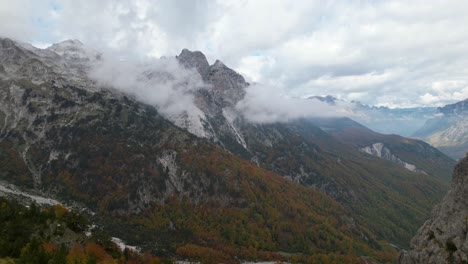 Wild-forest-and-high-mountains-in-the-Alps-of-Albania-in-Autumn-with-clouds-and-golden-trees
