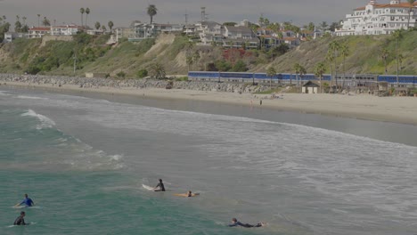 Amtrak-train-moving-through-San-Clamente-as-surfers-play-in-the-waves