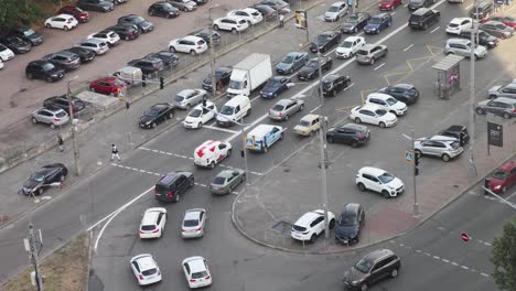 Tráfico-Diurno-En-La-Carretera-Entre-Estacionamientos-Con-Autos-Estacionados