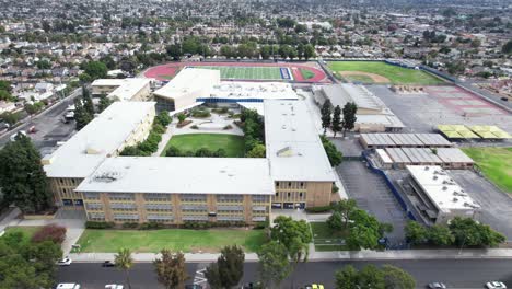 Aerial,-Crenshaw-high-school,-football-field-over-campus,-city-of-Los-Angeles
