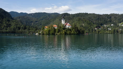 Mariä-Himmelfahrt-Kirche-Inmitten-Des-Ruhigen-Wassers-Des-Bleder-Sees-In-Den-Julischen-Alpen,-Slowenien