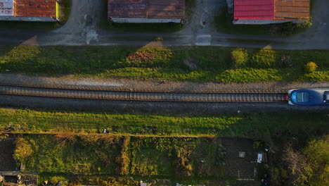 Aerial-view-of-the-top-of-a-train-passing-by-an-industrial-zone