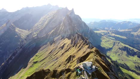 Aerial-flyover-over-Schaefler-ridge-in-Appenzell,-Switzerland-with-view-of-Alpstein-peaks-in-daylight