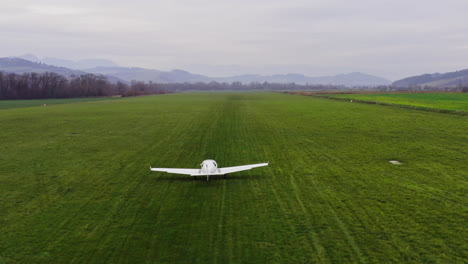 Small-air-place-taking-off-in-an-empty,-lush-green-field-in-the-rural-countryside-of-Liptov,-Slovakia