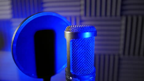 Dolly-shot-of-a-condenser-capacitor-microphone-in-a-voice-over-podcast-vocal-booth-in-a-recording-studio