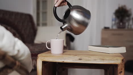 Pouring-hot-tea-kettle-rusctic-wood-table
