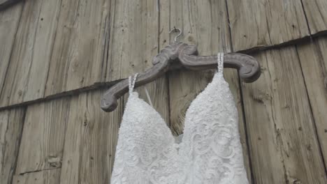 Schönes-Weißes-Brautkleid,-Das-An-Der-Rustikalen-Holzhalterung-Hängt