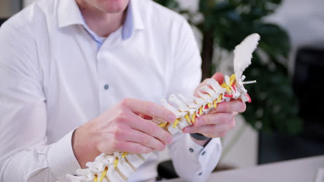 the-chiropractor-explains-to-the-patient-about-cervical-vertebrae-on-an-artificial-spine