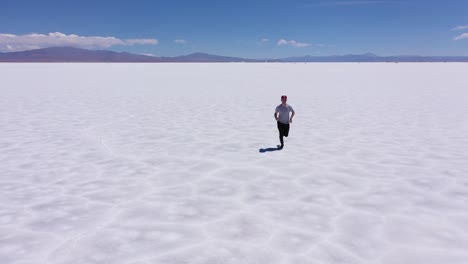 Young-man-running-in-the-middle-of-the-great-salt-flats-of-Jujuy-in-Argentina