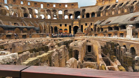 Wide-shot-showing-old-ruins-and-walls-inside-giant-Colosseum-Arena-during-sunny-day-in-Rome