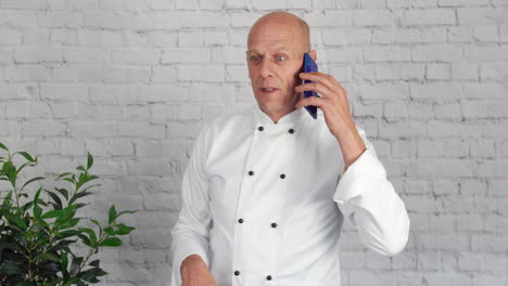 Head-chef-talking-on-the-phone-while-taking-a-break-from-the-kitchen