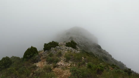 4k-Slow-motion-shot-of-a-rocky-path-high-up-in-the-clouds-on-a-large-mountain,-La-Concha
