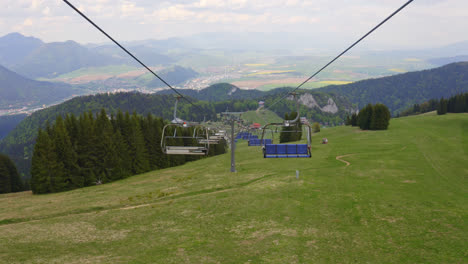 Malinô-Brdo-Bike-And-Ski-Resort,-Ružomberok,-Liptov,-Eslovaquia---Vista-De-Sillas-De-Telesilla-Vacías-Sobre-Un-Campo-Montañoso-Cubierto-De-Hierba-En-Verano