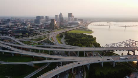Aerial-view-overlooking-the-bridges-and-the-cityscape-of-Louisville,-sunset-in-Kentucky,-USA---pan,-drone-shot