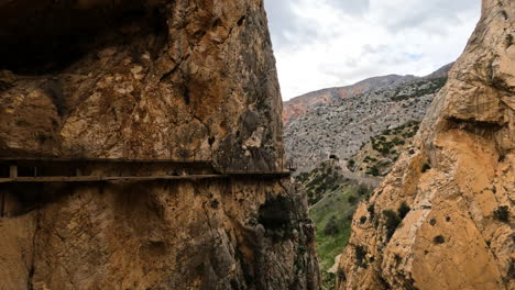 4k-Shot-of-a-wooden-bridge-on-the-side-of-a-mountain-cliff-at-El-Caminito-del-Rey-in-Gorge-Chorro,-Malaga-province,-Spain