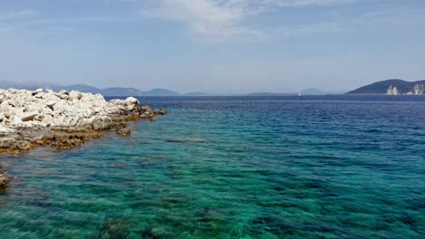 Paralia-Emplisi-With-Rocky-Coastline-And-Blue-Sea-On-A-Sunny-Summer-Day-In-Greece