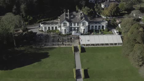 Retreating-aerial-of-elegant-Haven-Hotel-and-extensive-grounds,-IRL
