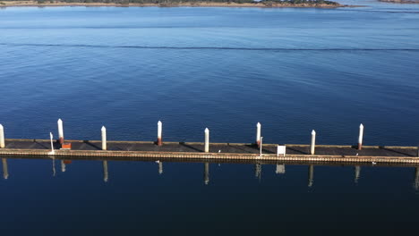 Fishing-dock-in-blue-Oregon-river,-high-angle-drone-view-sideways-left-to-right-flight