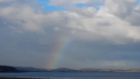 Scenic-colourful-rainbow-over-Welsh-mountains-coastal-seascape-horizon