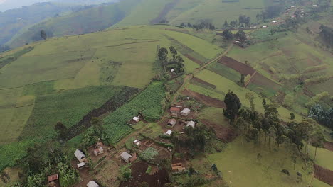 Low-misty-aerial-flight,-steep-hilly-agri-crop-fields-in-Congo,-Africa