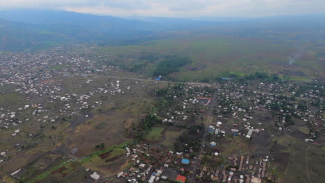 Heli-flight-along-highway-in-DRC-Congo-toward-Rift-Valley-town,-Sake