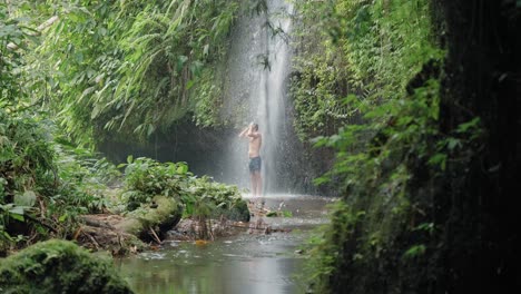 Attraktiver-Mann,-Der-Unter-Wasserfall-Duscht-Und-Sich-Am-Sommertag-Abkühlt