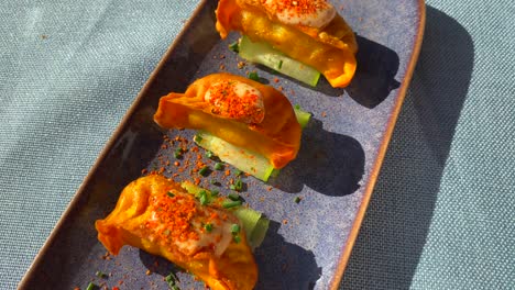 Delicious-mini-empanadas-with-cucumber-and-chili-dust-in-a-restaurant,-tasty-spanish-argentinian-food-in-Marbella-Estepona,-4K-top-view