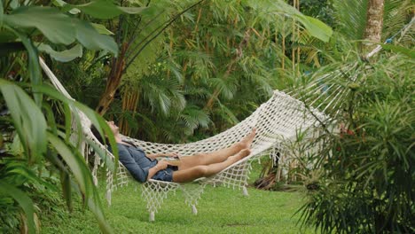 Attractive-man-lying-in-hammock-with-a-book