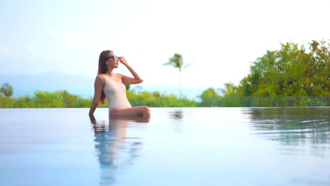 Sexy-Asian-Woman-on-Luxury-Vacation,-on-Poolside-With-Green-Tropical-Plants-in-Background,-Full-Frame