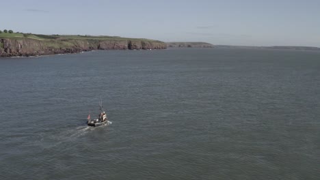 Aerial:-Lone-fishing-boat-motors-along-coastal-cliffs-of-Ireland