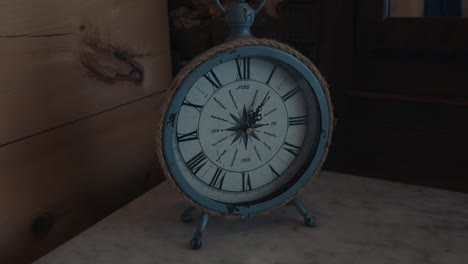Close-up-view-of-white-vintage-clock-in-classical-design-on-a-table-in-a-house