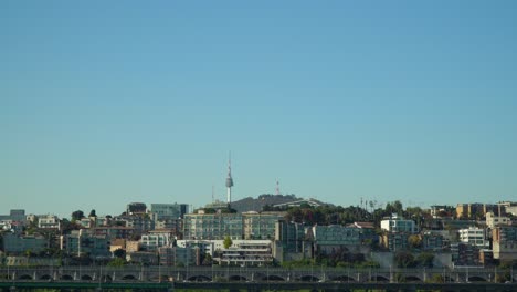 Namsan-Tower-seen-over-the-Yongsan-District-of-Seoul,-South-Korea-city-skyline---traffic-and-cityscape-on-a-clear-day,-copy-space