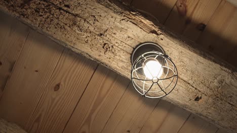 Retro-light-bulb-is-glowing-on-the-wooden-ceiling,-wedding-cached-moments