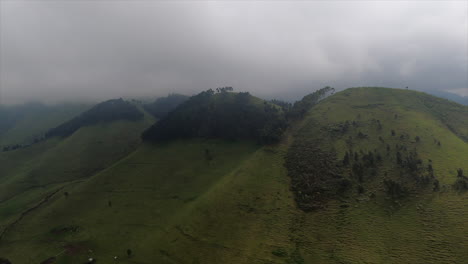 Heavy-low-overcast-on-aerial-flight,-green-grass-hills-of-Rift-Valley