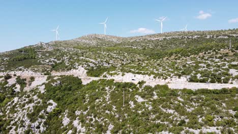 Aerial-Drone-View-of-the-Coastal-Road-in-Dalmatia,-Croatia-with-Driving-Cars-and-Windmills
