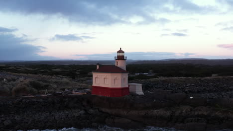 Coquille-River-Lighthouse-in-Bandon-Oregon-at-sunrise,-drone-pull-back-shot