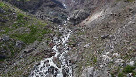 Luftflug-Auf-Eine-Massive-Bergformation-Mit-Wildem-Wasserfall-Und-Fluss,-Atemberaubende-Drohnenaufnahme-In-Den-Schweizer-Alpen-In-Saas-Fee