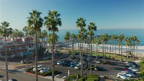 Rising-aerial-view-of-the-San-Clemente-pier-over-tall-palm-trees