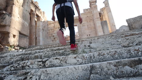 A-man-in-red-shoes-walks-up-ancient-marble-steps