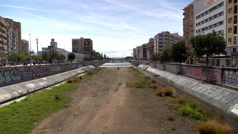Dried-out-river-bed-in-urban-city-with-Graffiti-on-walls