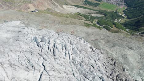 drone-flight-over-ice-glacier-with-crevasses,-the-end-of-a-glacier-melting-during-summer-with-black-ridges,-Aerial-fly-over-of-allalingletscher-switzerland