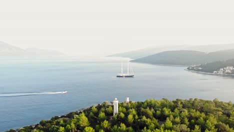 Panoramablick-Auf-Idyllische-Meereslandschaft,-Yacht-Und-Leuchtturm-Von-Fiskardo-In-Kefalonia,-Griechenland---Drohnenaufnahme