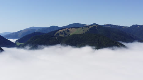 Beautiful-mountain-peaks-and-valleys-of-Liptov,-Slovakia,-aerial-pull-back-shot-disappearing-into-the-thick-clouds