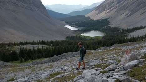 hiker-walking-down-Mountain-valley-Rockies-Kananaskis-Alberta-Canada
